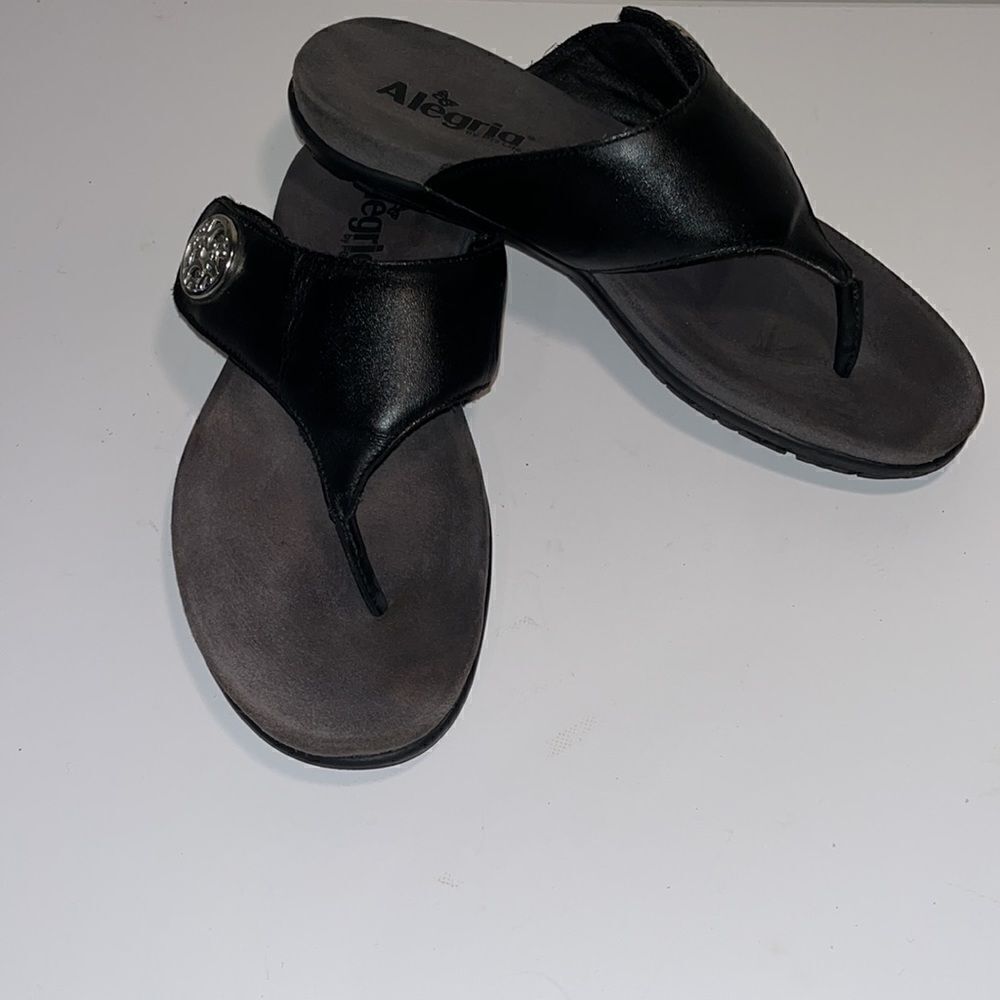 Alegria black leather thong sandals.